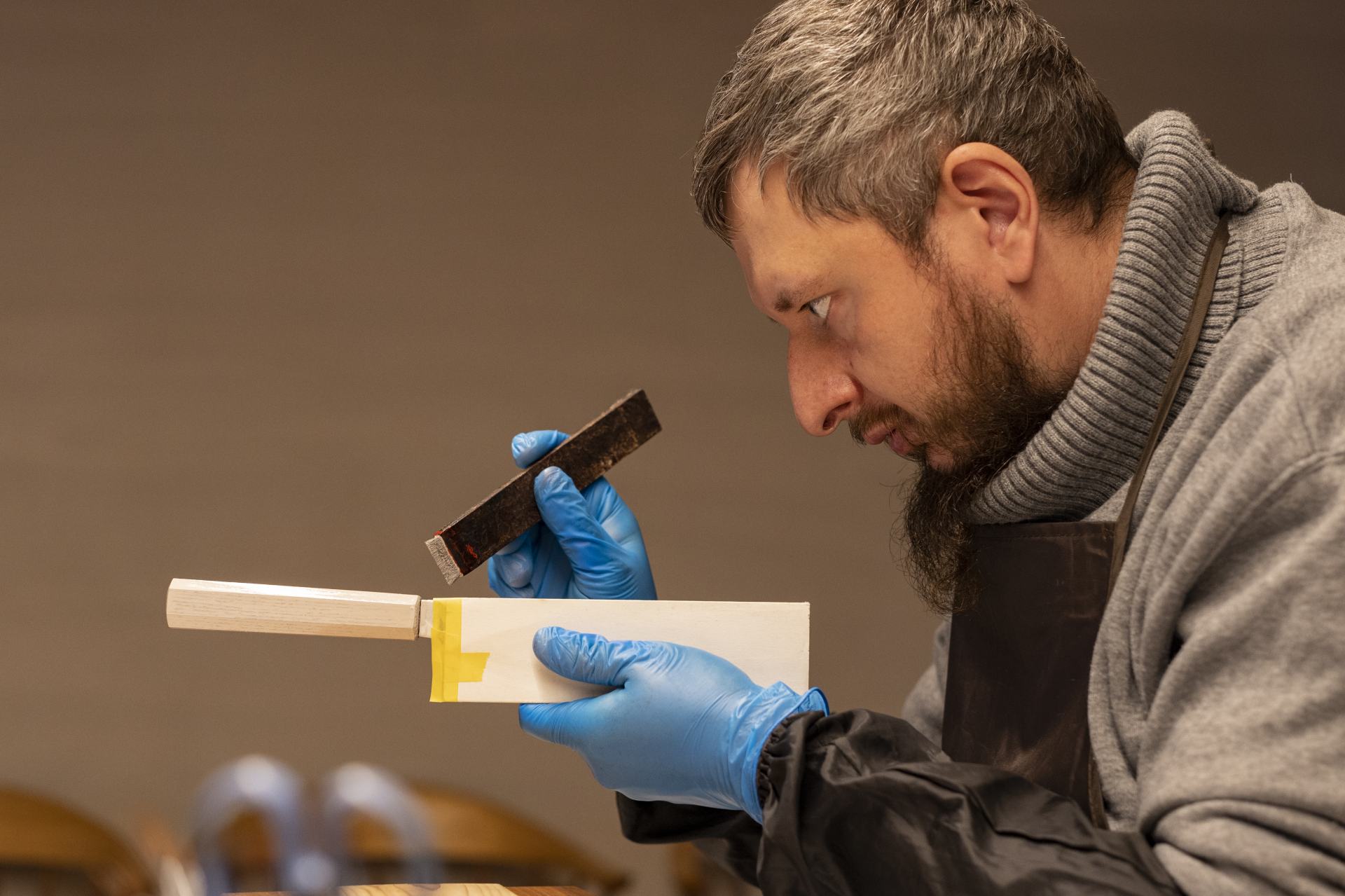 Lacquering the wooden handles with a brush made from human hair.