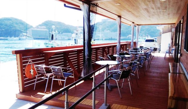 The wooden dining area with a view of the ocean.