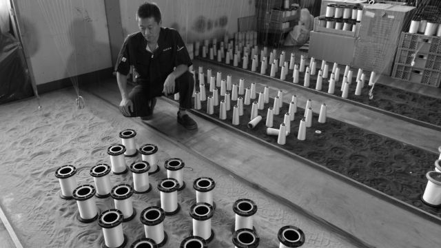 The process of preparing the warp threads needed to manufacture textiles is called “seikei.” The warp threads are laid out on sand and then wound onto large bobbins.