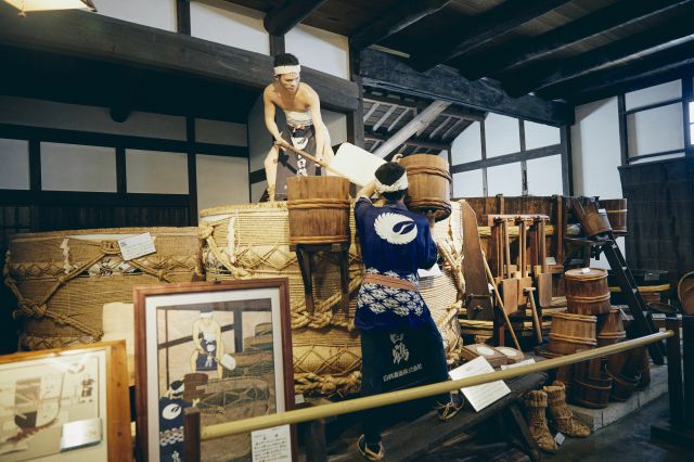 Old-fashioned sake brewing process and tools on display.